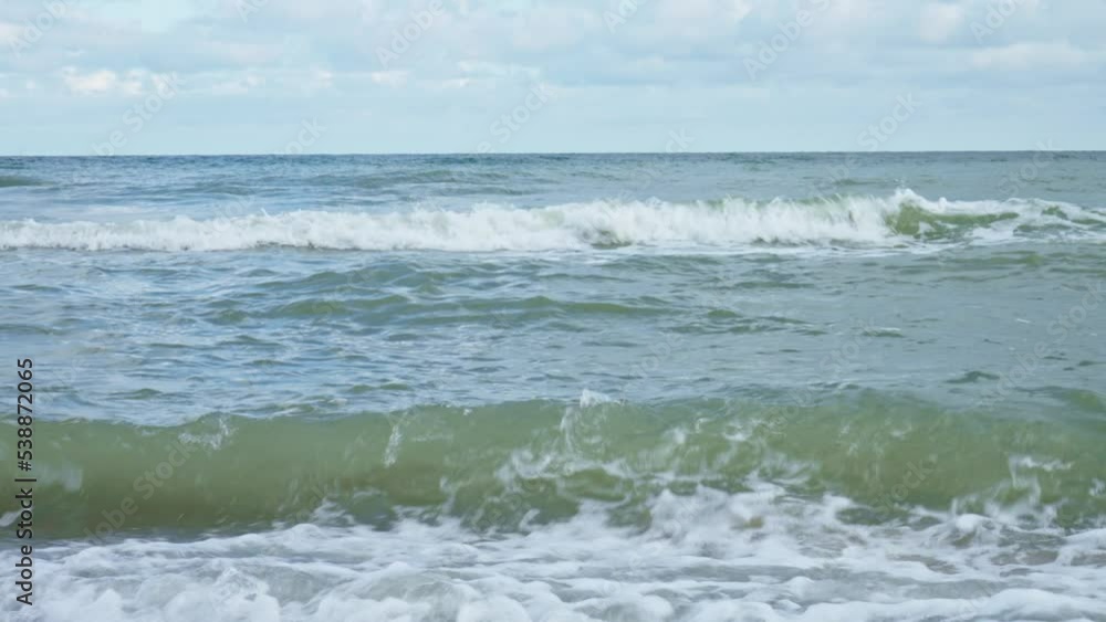Baltic sea seachore with waves, sand beach and beautiful cloudy sky without people, Summer travel and vacation in Poland Baltic sea seachore with waves, sand beach and beautiful cloudy sky without people, Summer travel and vacation in Poland