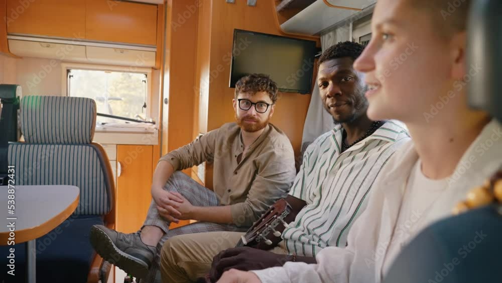 Van life and traveling. Three people of different nationalities and ethnicities sitting inside the camper and talking about their life. True friendship. High quality 4k footage Van life and traveling. Three people of different nationalities and ethnicities sitting inside the camper and talking about their life. True friendship. High quality 4k footage