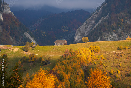 Autumn landscape in Romania. Beautiful sightseeing with the fall landscape from villages of Rucar Bran passage in Transylvania with old houses and folk scenery views. Wide angle view. photo