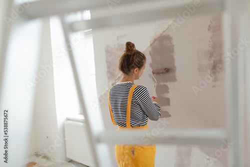 Tableau sur toile Happy young woman remaking her new flat, painting walls