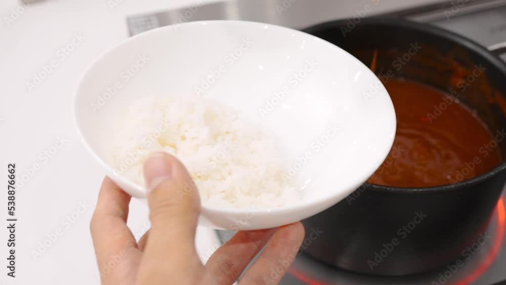 白いご飯にカレーをよそう主婦の手元 白いご飯にカレーをよそう主婦の手元
