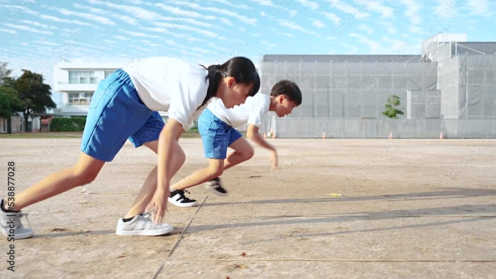 Stockvideon 学校の校庭を走っている小学生の男の子と女の子 | Adobe Stock