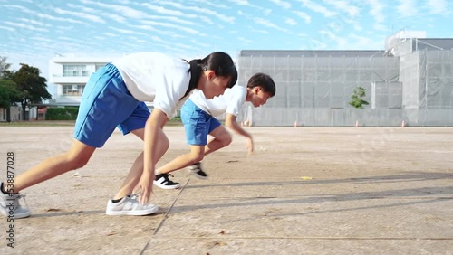 学校の校庭を走っている小学生の男の子と女の子
