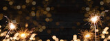Sylvester, New Year's Eve 2023 Party, New year, Fireworks, Firework celebration background banner panorama long- Sparklers and bokeh lights on rustic black wooden wall texture.