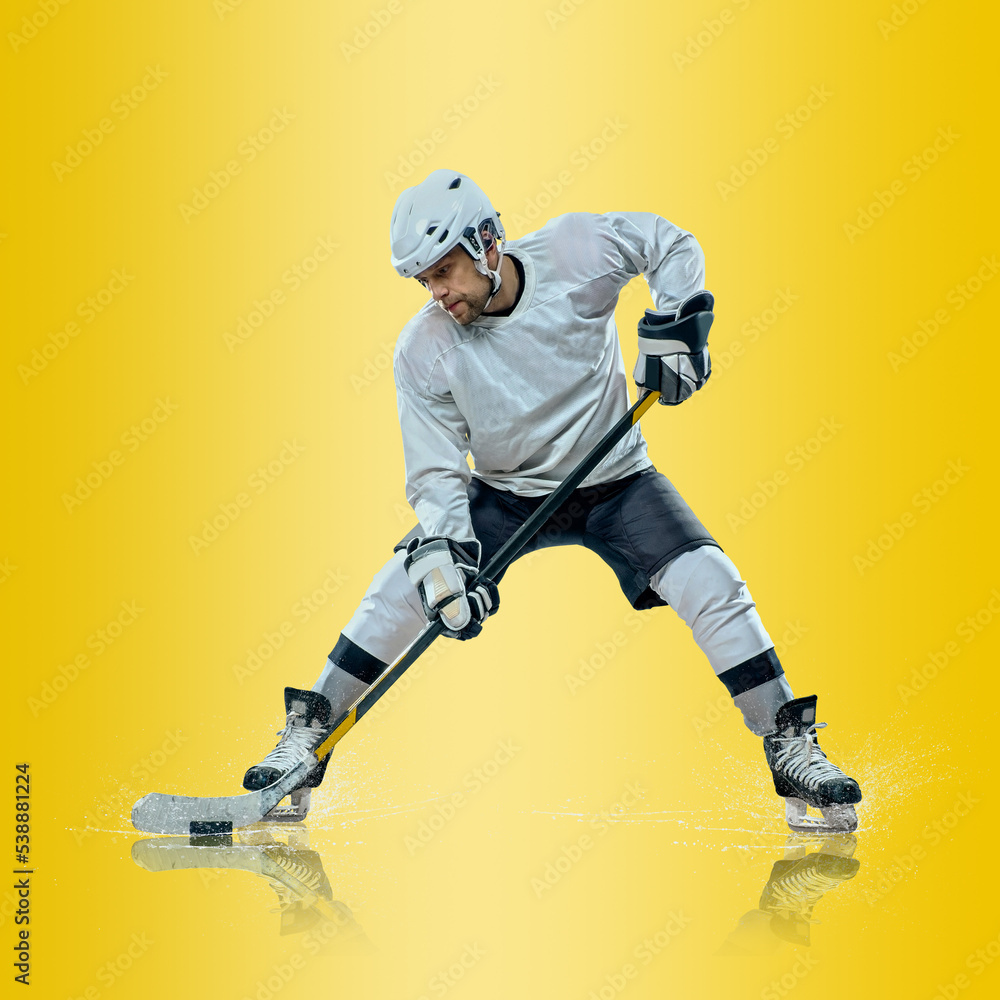 Professional ice hockey player hitting puck for winning goal in action on gradient multicolored neon background. Concept of sport competition. Professional ice hockey player hitting puck for winning goal in action on gradient multicolored neon background. Concept of sport competition.