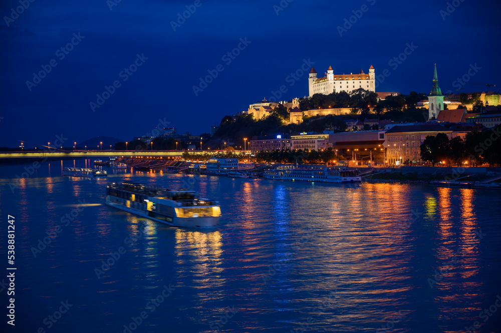 Danube river cruise boat. Bratislava Castle at night