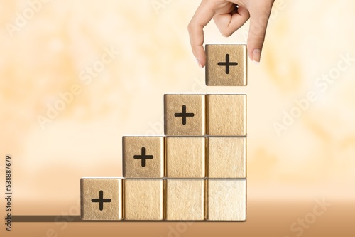 Positive plus icon sign on the wooden cubes