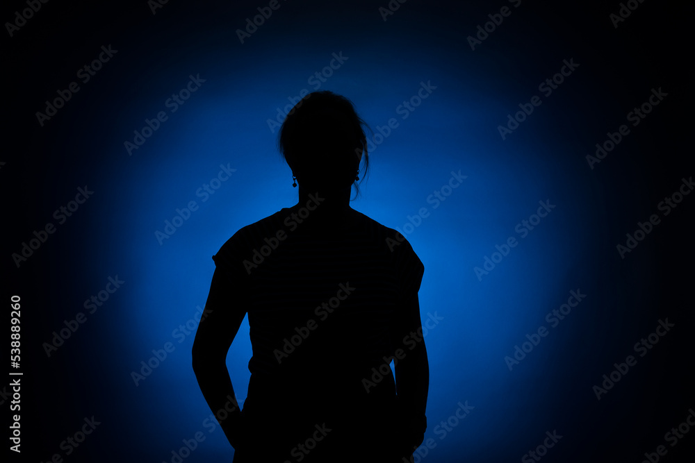 silhouette of a woman on a round blue spot on a black background