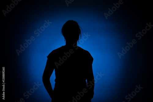 silhouette of a woman on a round blue spot on a black background
