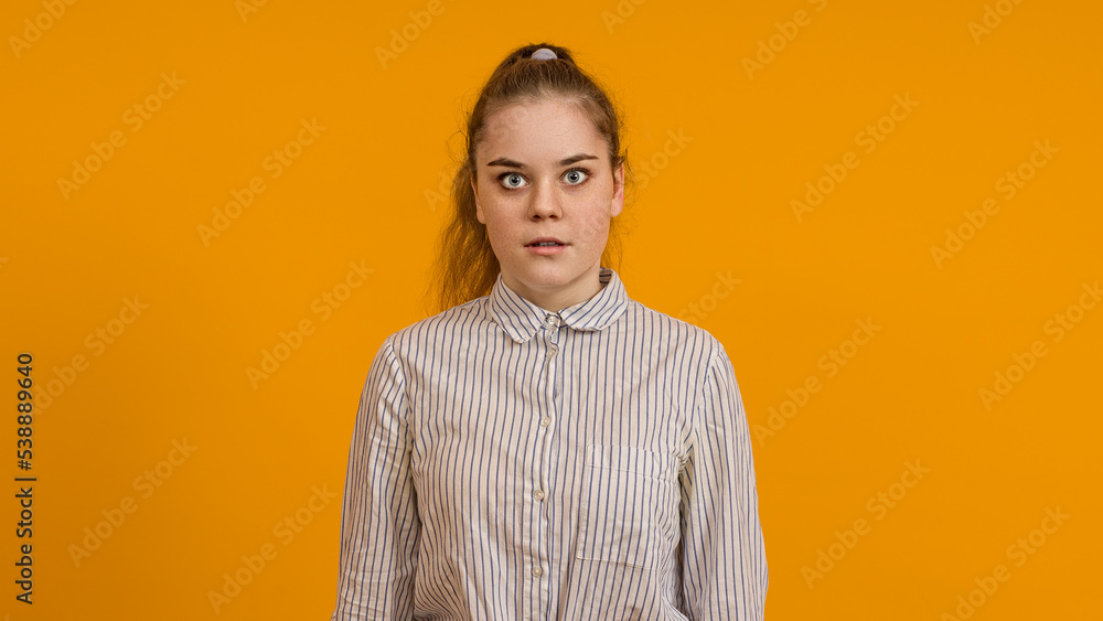 Fototapeta premium surprised young girl teenager magnified her eyes on a colored background