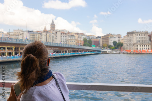 Tourist woman looking to the Galata Tower in a ferry on Bosphorus