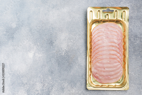 Pork ham in thin slices in a vacuum package on the table. Meat sliced carbonate in a package for long-term storage.
