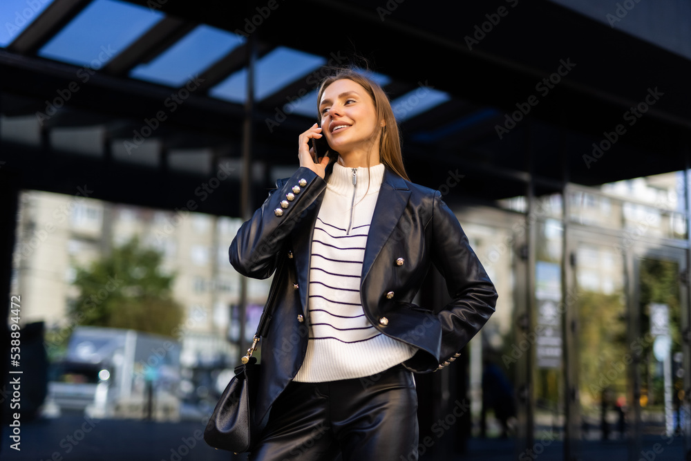 Fototapeta premium Attractive business woman talking on mobile phone with client.