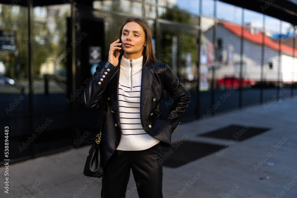Obraz premium Attractive business woman talking on mobile phone with client.