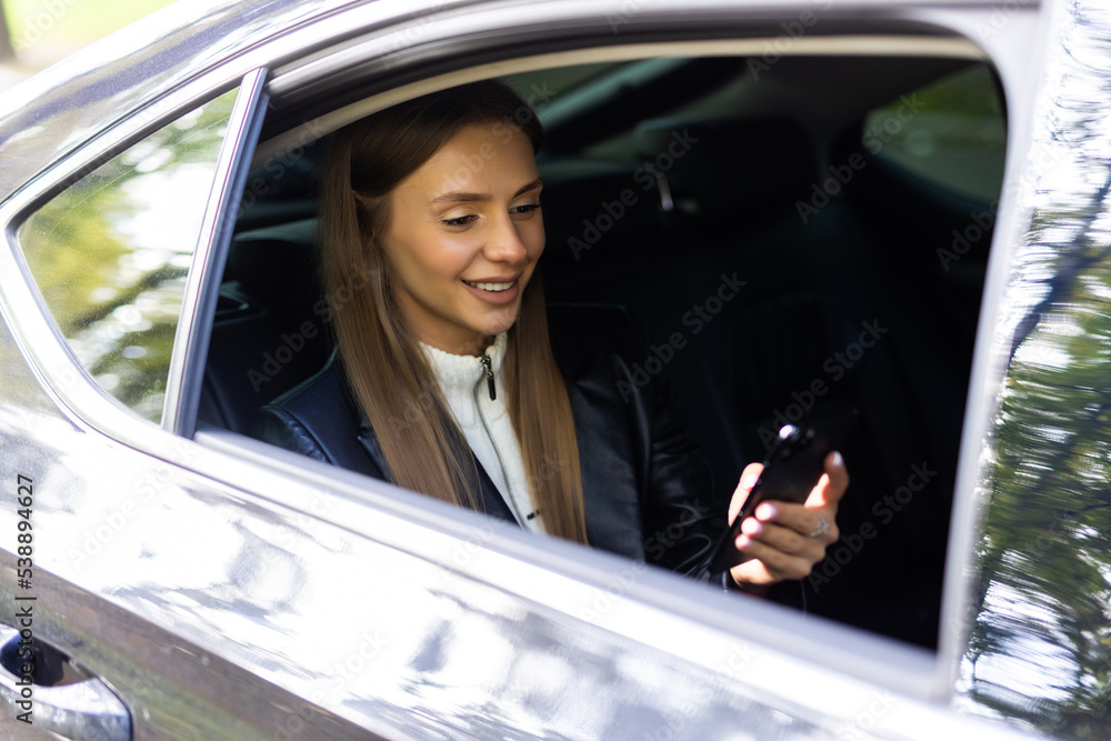 Transport, vehicle and technology concept. smiling woman in taxi car using smartphone