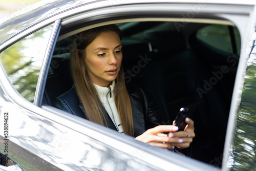 Transport, vehicle and technology concept. smiling woman in taxi car using smartphone