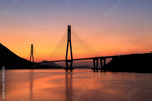 朝焼けに染まる海と橋 © 鉄朗 廣田