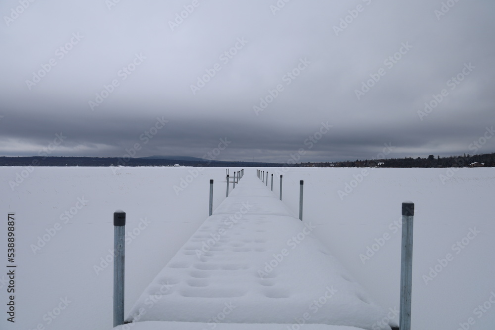 Ponton de bateau pris dans la glace sur un lac pendant l'hiver au Canada