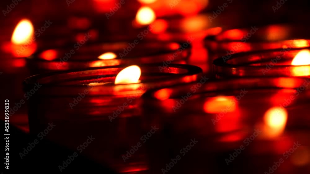 Flames of burning close up view red candles in a row in a catholic church Flames of burning close up view red candles in a row in a catholic church
