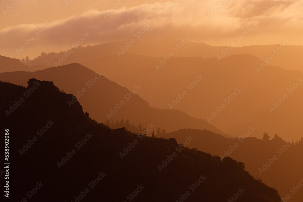 Layer of mountains under the golden sunlight.