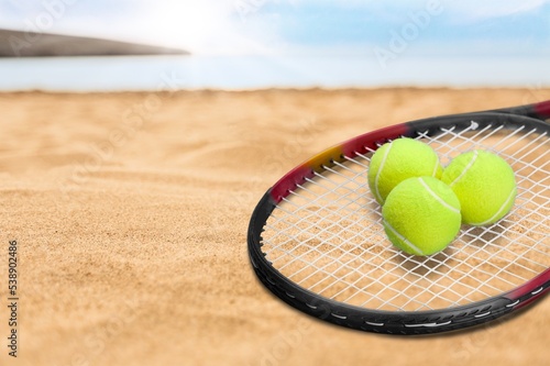 Racket and classic ball on beach for sport concept. © BillionPhotos.com