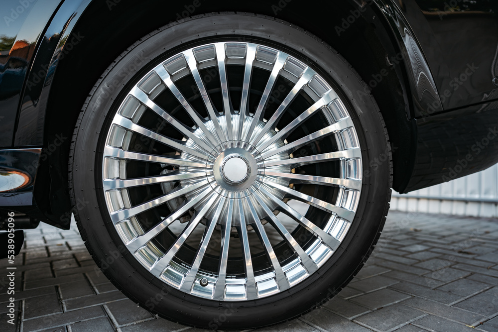 Aluminium rim of luxury black suv car wheel close up