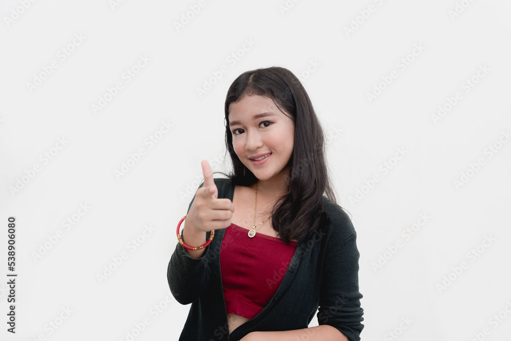 An Asian teenager smiles while pointing at the camera doing a An Asian teenager smiles while pointing at the camera doing a