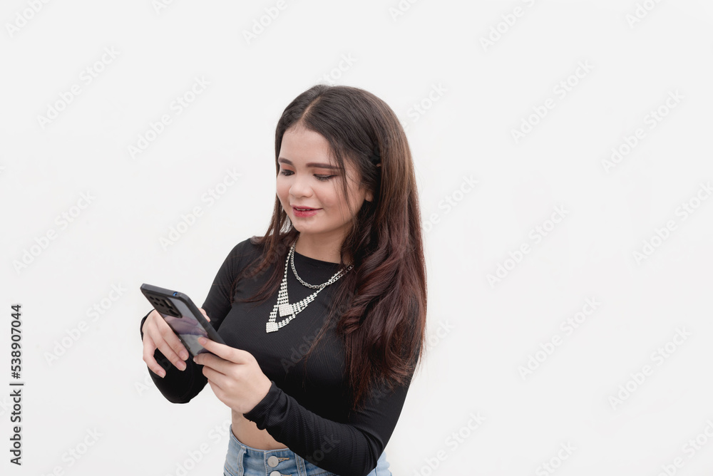 A young lady surfs the internet using her phone to check her social media accounts. Studio shot isolated on a white background. A young lady surfs the internet using her phone to check her social media accounts. Studio shot isolated on a white background.