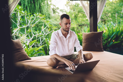 Millennial freelance copywriter creating web text and content for sharing in social media during networking time, skilled programmer editing data code while doing distance job at comfortable terrace
