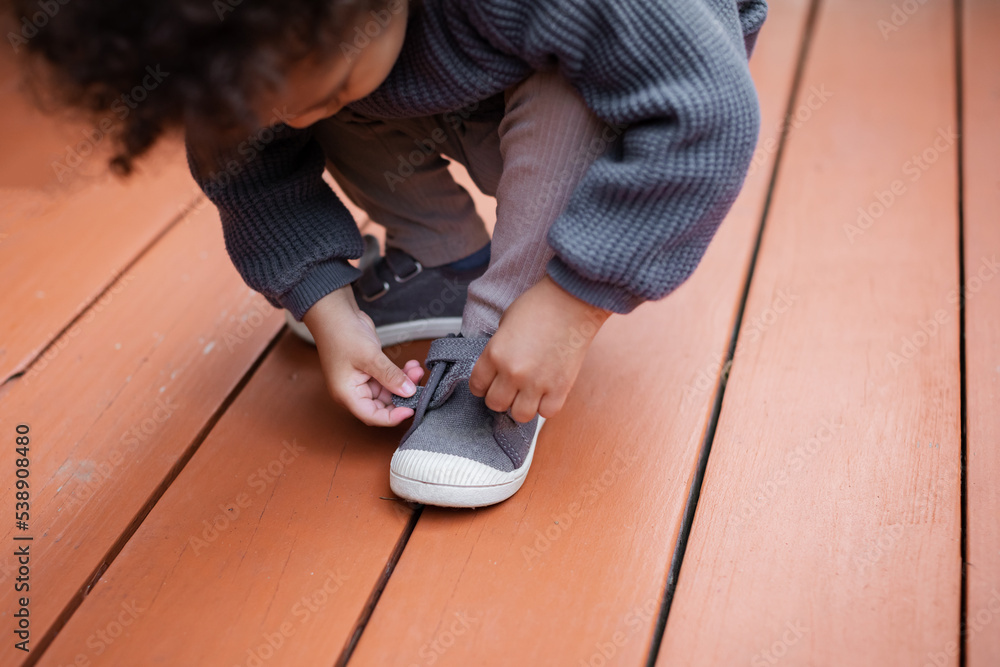 Biracial toddler putting on shoe Stock Photo Adobe Stock