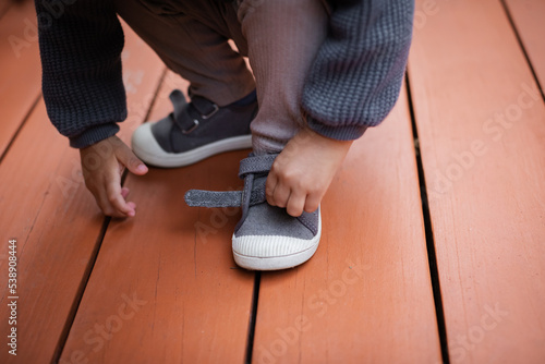 Photos Close up of Biracial toddler putting on Velcro shoe