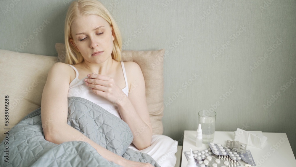 Cold flu season, runny nose. Sick girl on bed sneezing in handkerchief in bedroom Cold flu season, runny nose. Sick girl on bed sneezing in handkerchief in bedroom