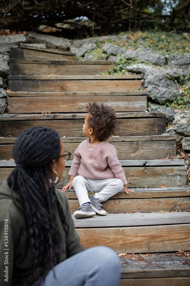 Biracial mother and child on stairs outside in fall/autumn Biracial mother and child on stairs outside in fall/autumn