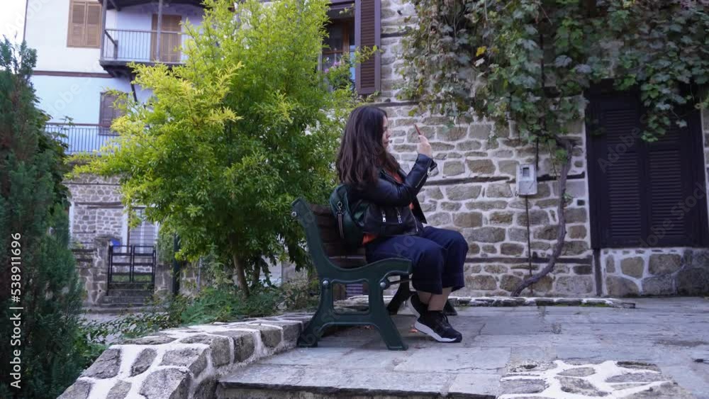 A girl sitting and taking pictures of old houses in Halkidiki, Greece. A girl sitting and taking pictures of old houses in Halkidiki, Greece.
