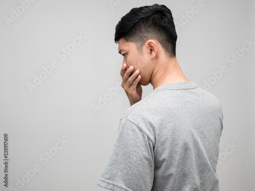 Asian man grey shirt turn back worried emotion isolated