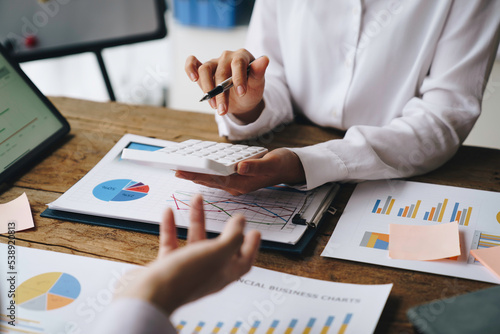 Financial analysts analyze business financial reports on digital tablets during conversations at corporate meetings, showing results of successful teamwork. business meeting ideas marketing
