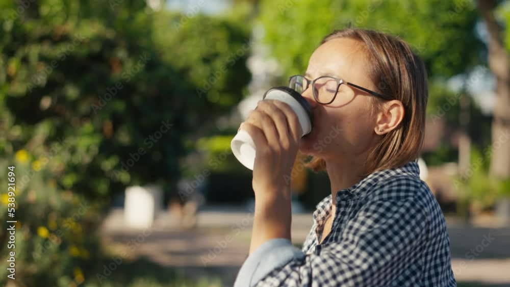 Young woman in park with tablet and takeaway coffee. Young woman in park with tablet and takeaway coffee.