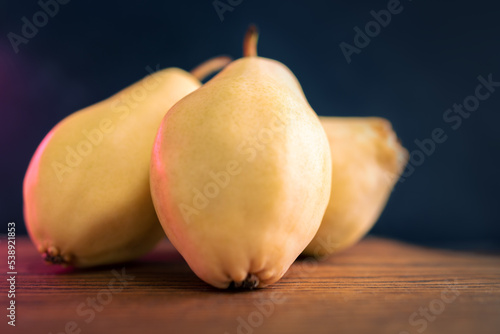 Three Whole Pears Paced On A Slate Board. Healthy Food. Eco-Friendly Products. Selective Focus. Side View. Dark Background.