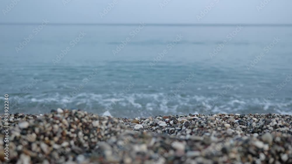 Small sea waves rush onto the shore from small pebbles. Straight close-up, perpendicular to the sea line. Peace from the movement of sea water or waves. High quality FullHD footage Small sea waves rush onto the shore from small pebbles. Straight close-up, perpendicular to the sea line. Peace from the movement of sea water or waves. High quality FullHD footage