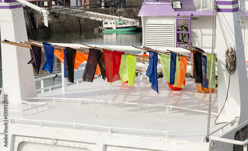 Drapeaux pour le repère des filets et casiers de pêche en mer rangés sur le pont d'un bateau dans un port photo