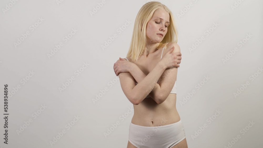 Woman in white panties posing in front of mirror, anti-cellulite cosmetics Woman in white panties posing in front of mirror, anti-cellulite cosmetics