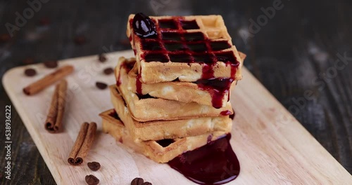 pour cherry jam on a soft waffle , a dessert of waffles with sweet cherry flavor and jam