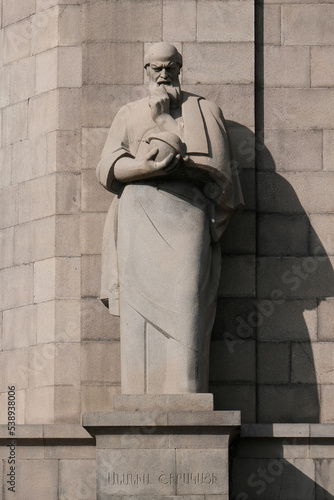 Anania Shirakatsi (Armenian medieval polymath and natural philosopher) statue in front of Matenadaran on sunny evening. Yerevan, Armenia. photo