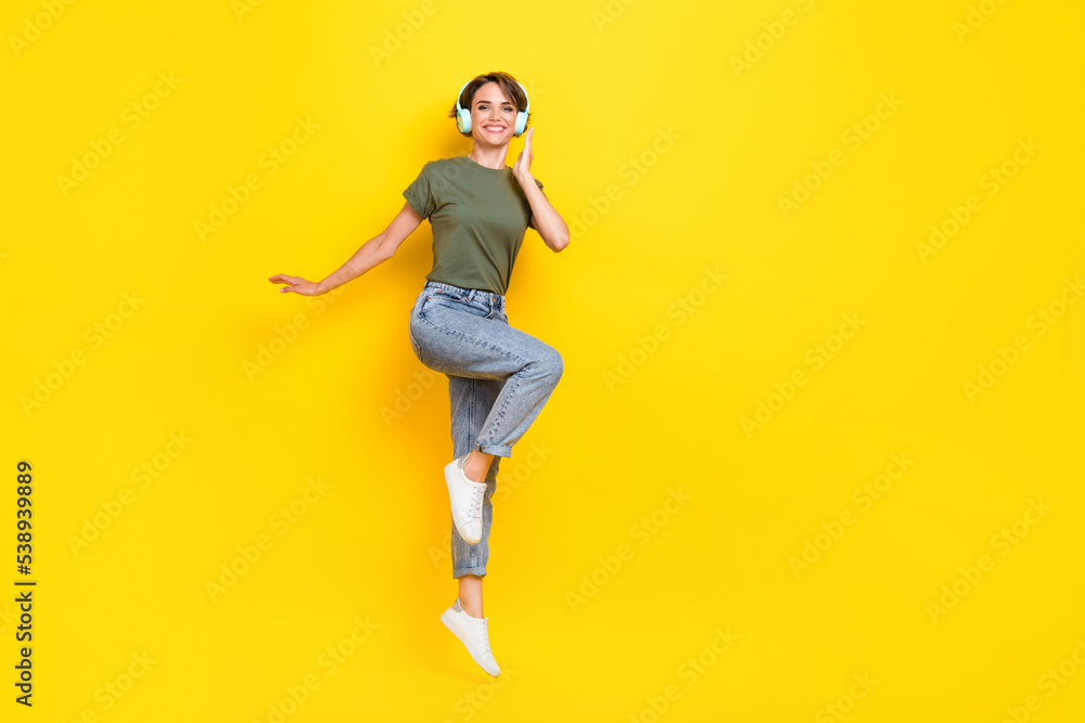 Full length photo of cheerful lady dressed stylish outfit rejoice discount device shop jump empty space isolated on yellow color background