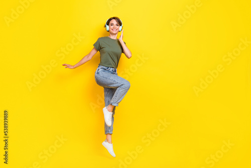 Full length photo of cheerful lady dressed stylish outfit rejoice discount device shop jump empty space isolated on yellow color background