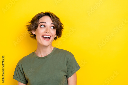 Portrait of satisfied sweet woman with bob hairdo dressed khaki t-shirt look empty space proposition isolated on yellow color background