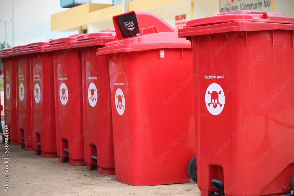 Stack of biological biohazard infected red bins. Sign showing the biological hazard symbol. According the world health organisation. Stack of biological biohazard infected red bins. Sign showing the biological hazard symbol. According the world health organisation.