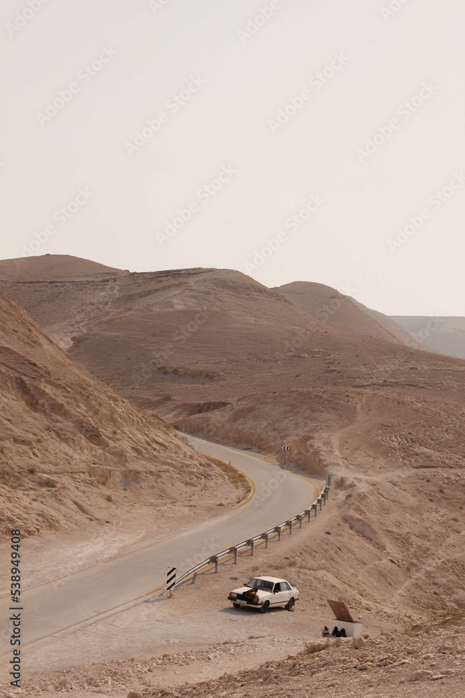 Road in the desert with a broken car Road in the desert with a broken car