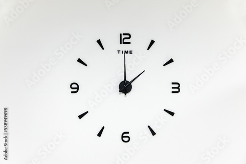 minimalistic black numbers and arrows of a wall clock on a white background photo