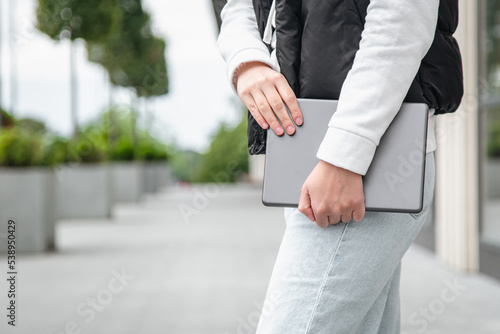 Tablet in the hands of a woman on a blurred background, part of the body.